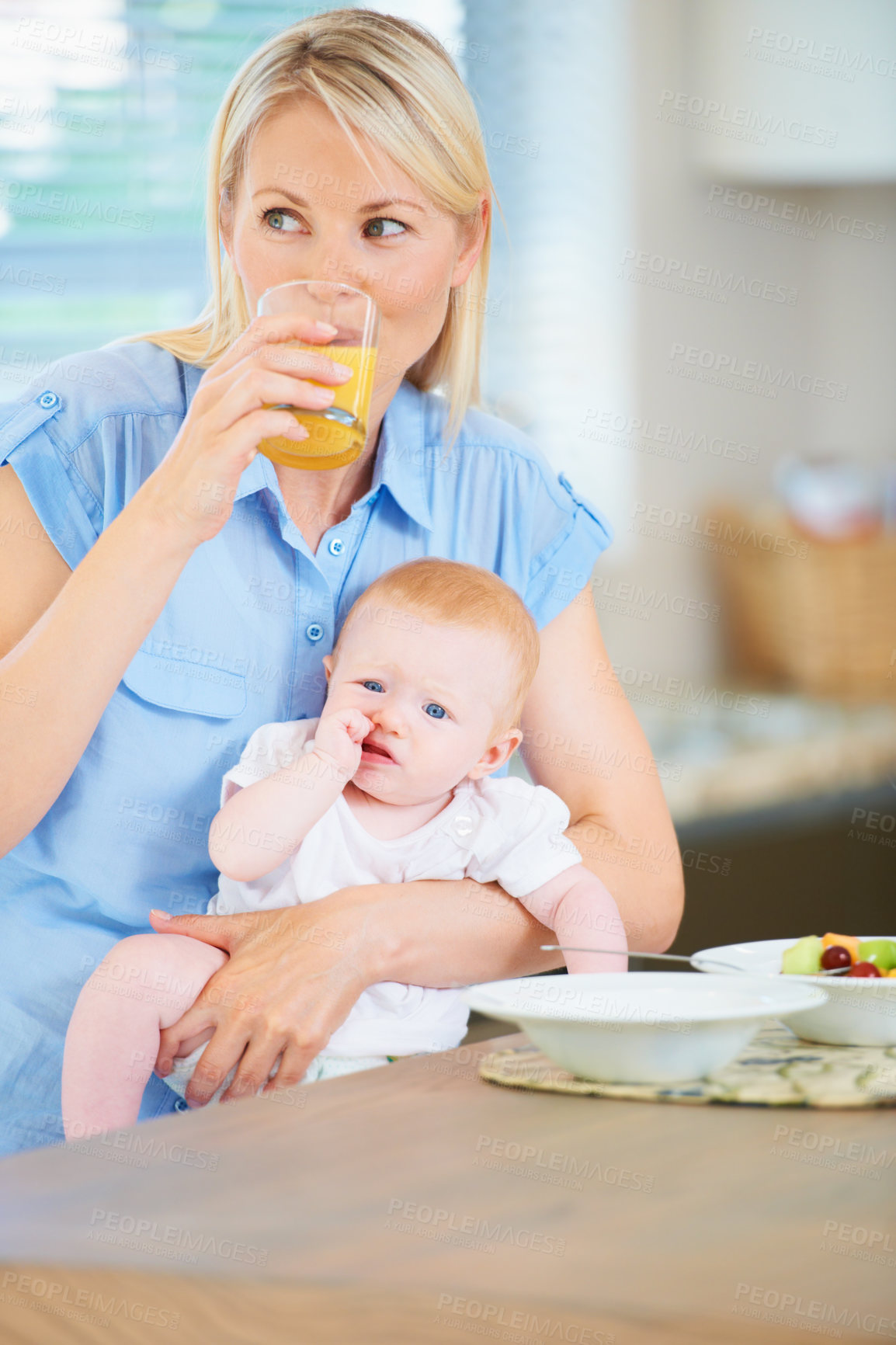 Buy stock photo A mother and her adorable baby girl sitting in the kitchen enjoying breakfast