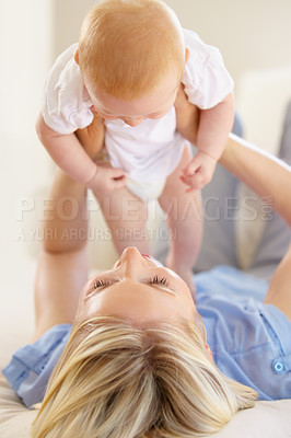 Buy stock photo An adorable baby girl being lifted into the air by her mother