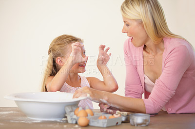 Buy stock photo Kitchen, baking and happy family playing, love and home mother and daughter bond, have fun and prepare recipe ingredients. Smile, goofy mama and silly kid learning cooking together with playful mom