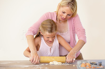 Buy stock photo A mother showing her daughter how to bake