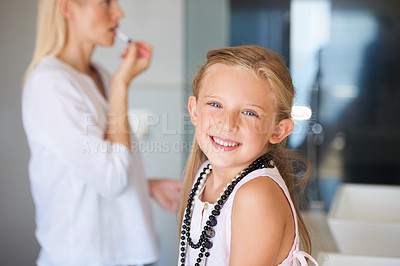 Buy stock photo Little girl sitting with her mother as she applies her makeup