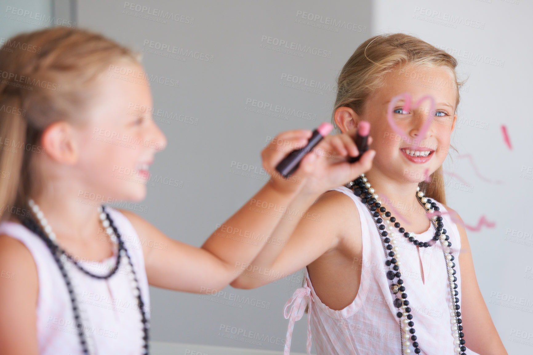 Buy stock photo Little girl, makeup and writing on mirror in bathroom for mess, naughty and bad behavior. Youth, kid and happy for drawing with lipstick, pink and cosmetics for beauty with smile for portrait in home