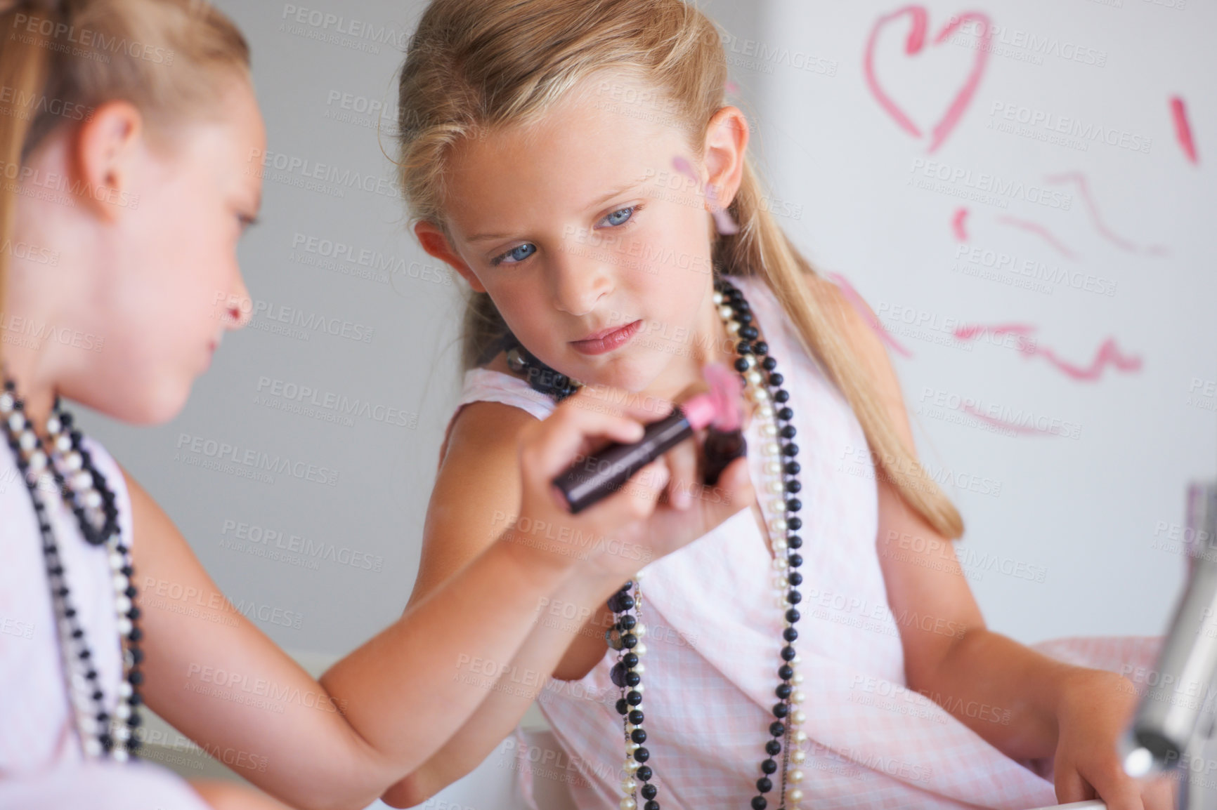 Buy stock photo Little girl, lipstick and heart on mirror in bathroom for drawing, fun and picture with bad behavior. Young, child and determined expression for writing with cosmetics for trouble, mess or problem
