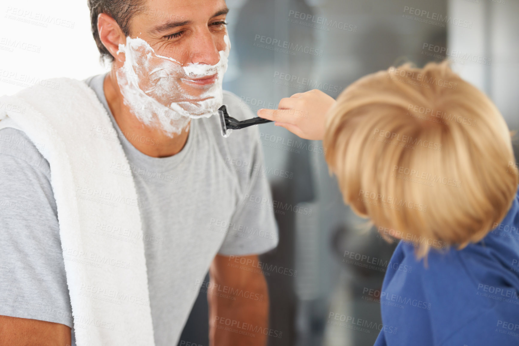 Buy stock photo A young boy shaving his father's beard