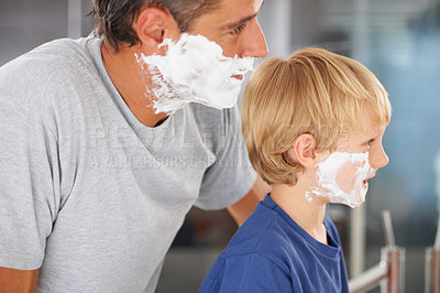 Buy stock photo A cute little boy with a face full of shaving cream and his father next to him