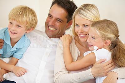 Buy stock photo Family, hug and happy on sofa with love, relax and peace for bonding and relationship in living room. Parents, children and face with smile on couch of lounge with embrace, break and care in home