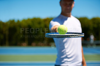 Buy stock photo Shot of a man balancing a tennis ball on his racket