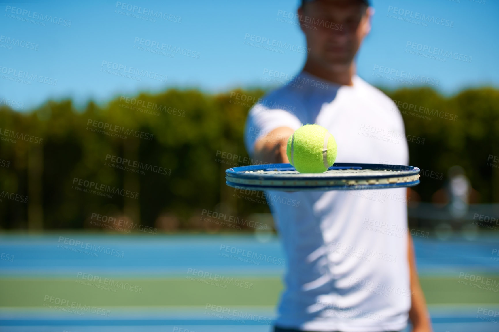 Buy stock photo Shot of a man balancing a tennis ball on his racket