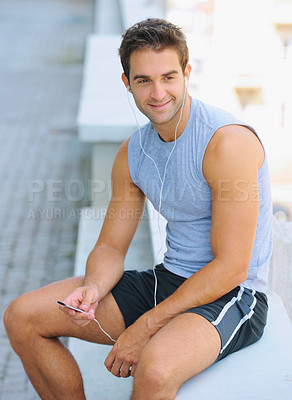 Buy stock photo Happy young jogger sitting outside and listening to music