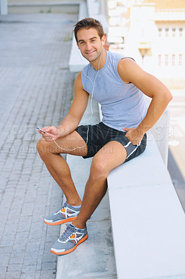 Buy stock photo Handsome man, portrait and sitting in fitness on break from exercise, workout or outdoor training on balcony in city. Happy male person smile with earphones listening to music in rest after cardio