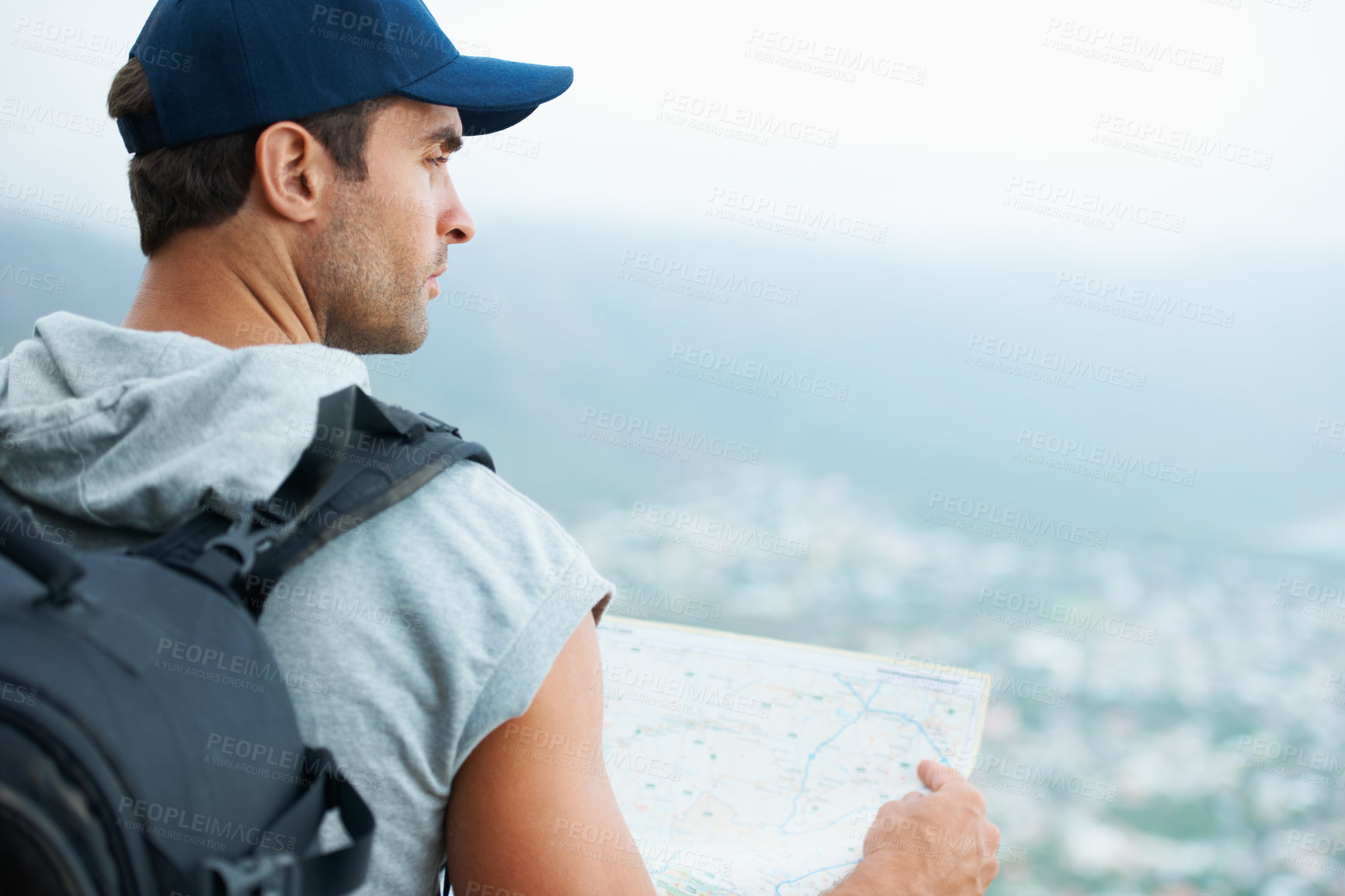 Buy stock photo Young hiker holding a map and looking at the scenic view