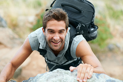 Buy stock photo Young mountain climber smiling up at the camera