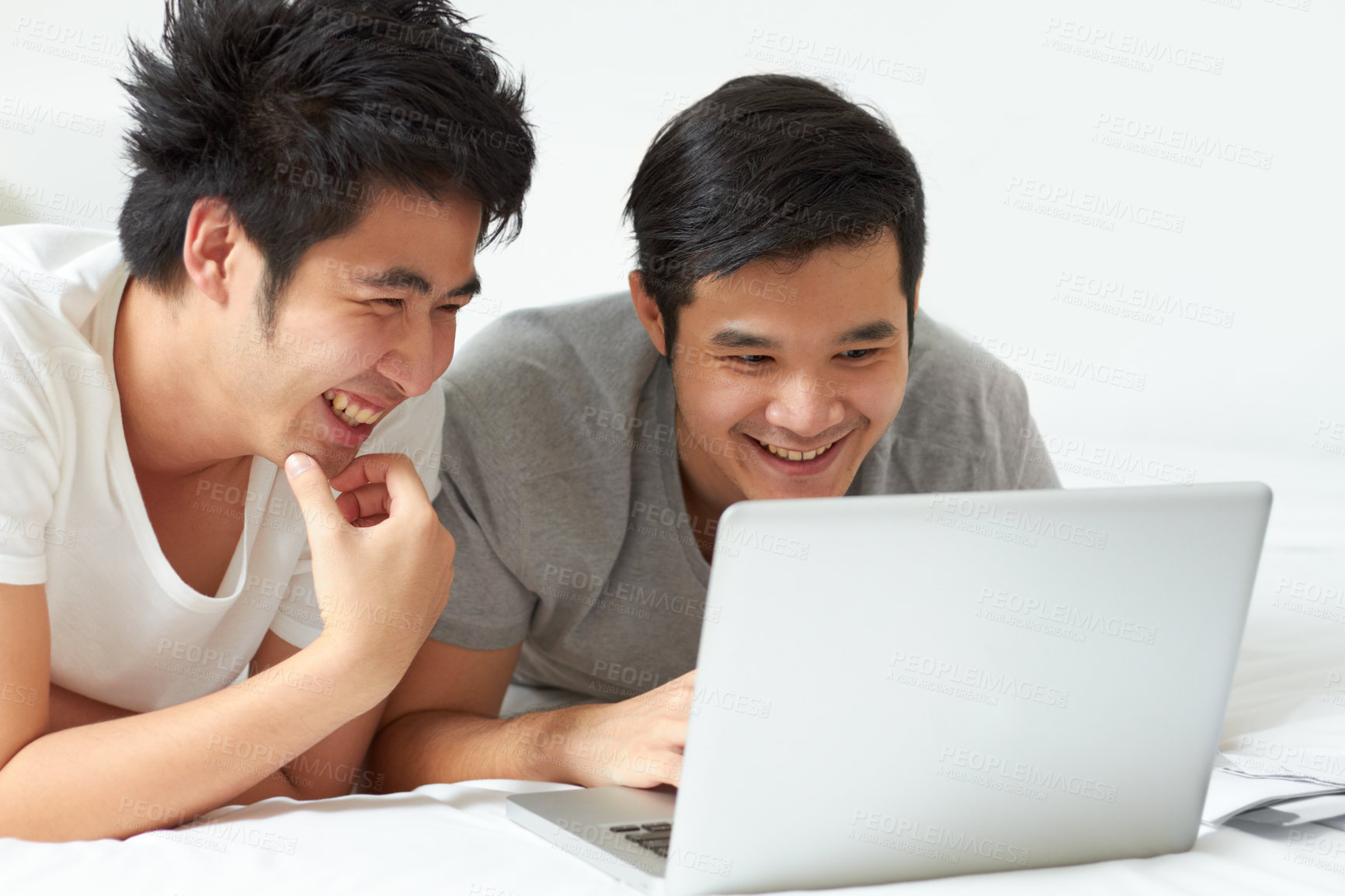 Buy stock photo LGBT, laptop and an asian couple in bed together, watching a movie or reading an email in the morning. Love, smile or happy with a gay man and partner streaming an online subscription in the bedroom