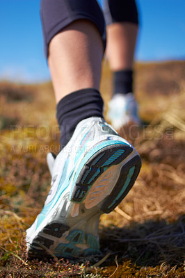 Buy stock photo A cropped shot of a woman's running shoe as she is running on a nature trail
