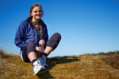 Buy stock photo Shot of a young woman resting after her outdoors workout
