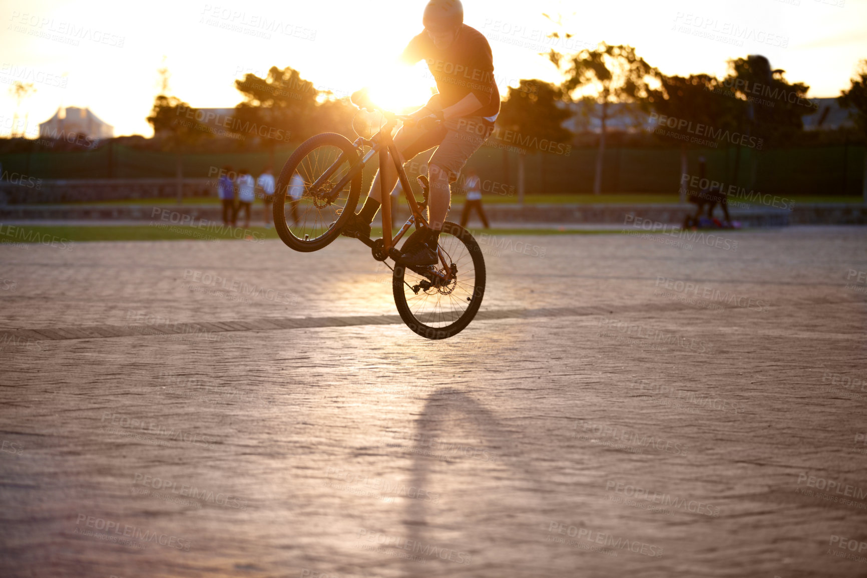 Buy stock photo Shot of a man doing tricks on his bike, with sun flare