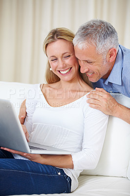 Buy stock photo Mature couple, laptop and video call with embrace, conversation and living room couch. Social media, technology and communication with family, man and woman with connection, streaming and happy
