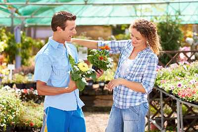 Buy stock photo Cropped shot of a young couple picking out flowers in a boutique