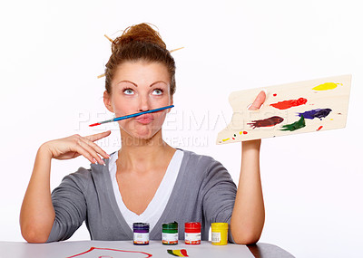 Buy stock photo Studio shot of an attractive woman balancing a paint brush on her upper lip