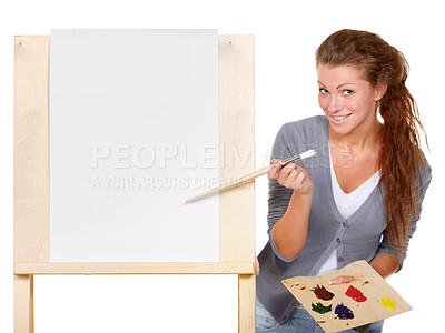 Buy stock photo Studio shot of a young woman holding a palette and brush and standing with an easel