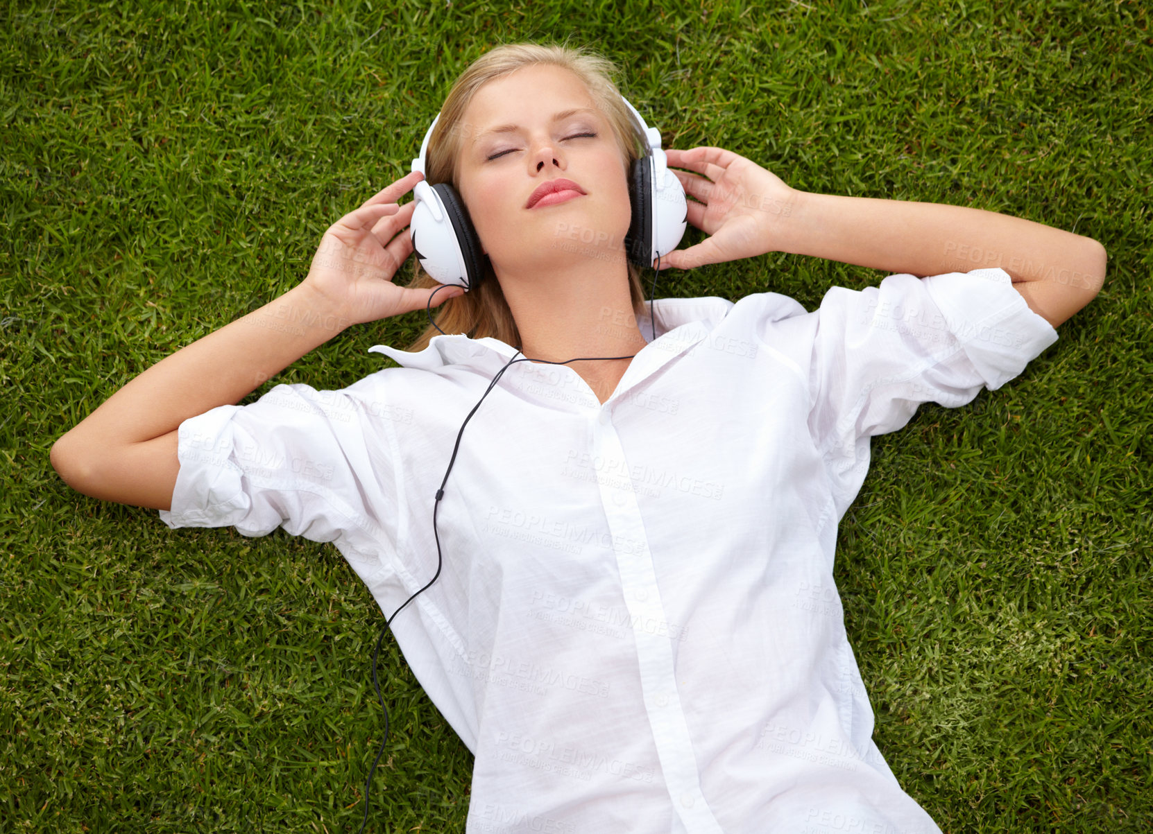 Buy stock photo Woman, relax on grass and listening to music with audio streaming service and mental health in park or garden. Young student sleeping or dream of electronics with headphones on lawn or floor above