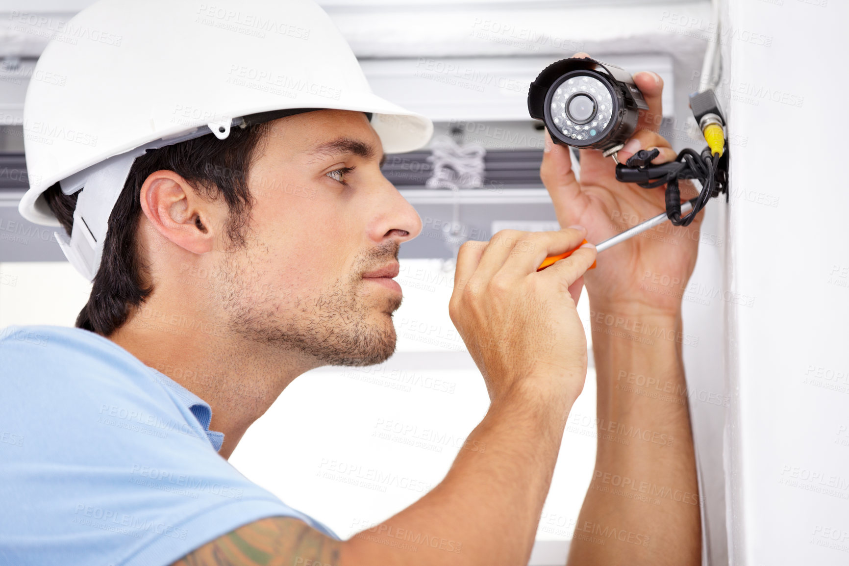 Buy stock photo Shot of a handsome young man    installing a security camera