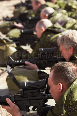 Buy stock photo A line of soldiers lying and aiming with their guns