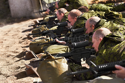Buy stock photo A line of soldiers lying and aiming with their guns