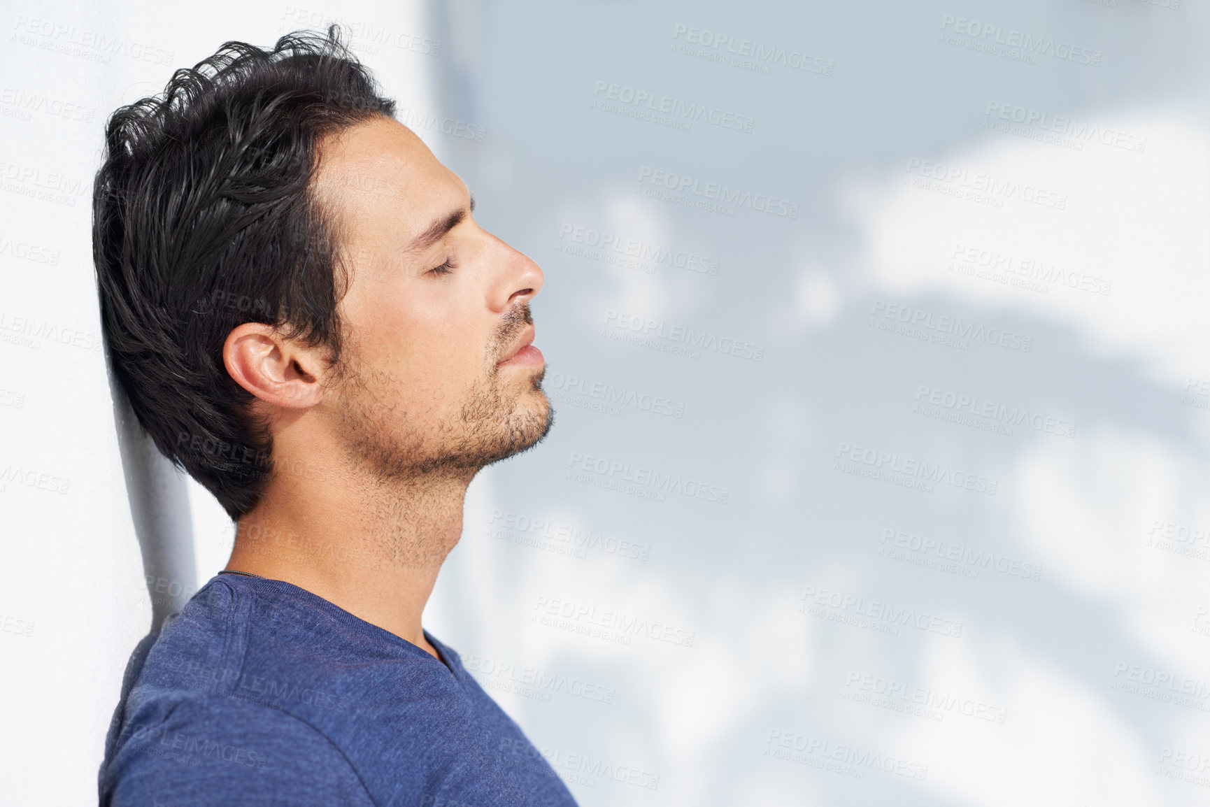Buy stock photo Thinking, calm and man profile by a white wall outdoor in the sun with freedom and ideas. Relax, peace and male person with mockup and summer with vitamin D, leaning and contemplating with outfit
