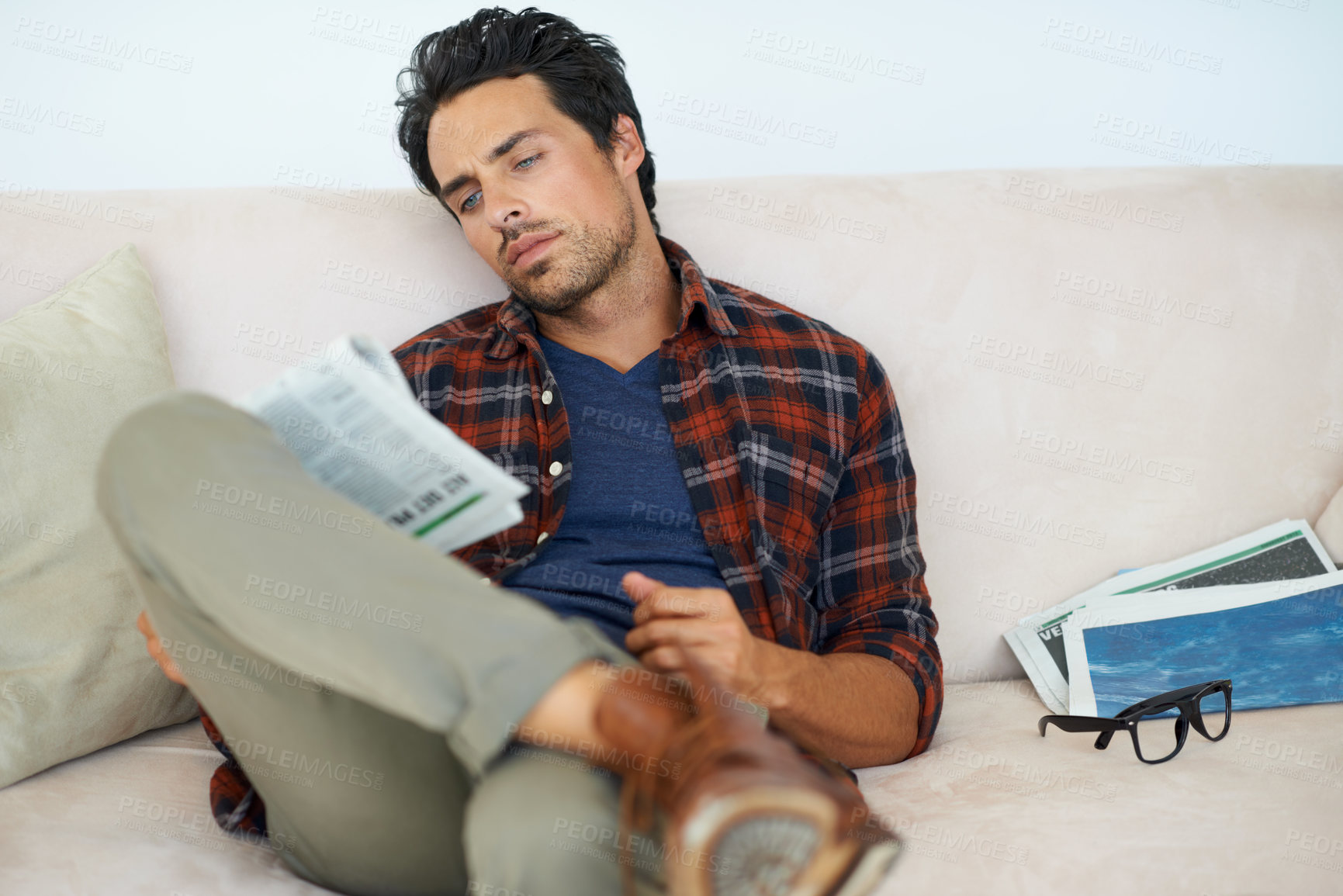 Buy stock photo Man, reading and relax with newspaper on couch in home, living room and learning about event from media. Calm, weekend and person with news, paper or magazine on sofa in apartment for information