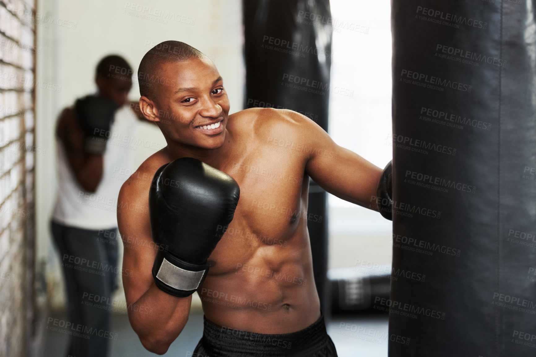 Buy stock photo Boxing, gloves and portrait of black man with bag, smile and  fitness, power and training challenge. Strong body, muscle and happy boxer in gym, athlete with confidence and pride in competition fight
