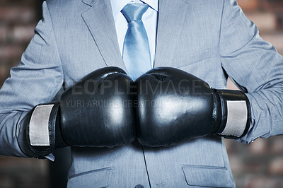 Buy stock photo A man in a suit punching his boxing gloves together