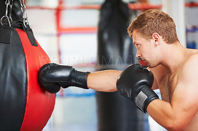 Buy stock photo Man, boxer and punching bag at gym for workout, exercise or self defense practice in fighting sport. Active male person boxing with gloves for energy, indoor training or martial arts at health club