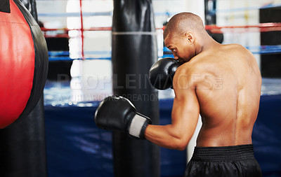 Buy stock photo Black man, boxer and punching bag at gym for workout, exercise or self defense practice in fighting sport. African male person with boxing gloves for indoor training or martial arts at health club