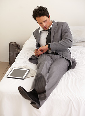 Buy stock photo Businessman, watch and checking time on bed at hotel for schedule, reservation or reminder at house. Man or employee looking at wristwatch for monitoring stay, deadline or accommodation in bedroom