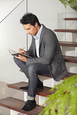 Buy stock photo Businessman, writing and sitting on stairs for journal, planning or reminder in living room at home. Man, freelancer or employee working or taking notes in book or diary for business plan or proposal