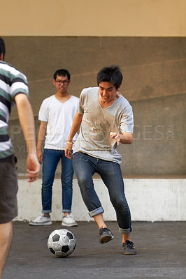Buy stock photo Friends in city street, man with football for sports, fun and happy energy with urban games in Korea. Game, friendship and group of young Asian men running in road with soccer ball for weekend time.