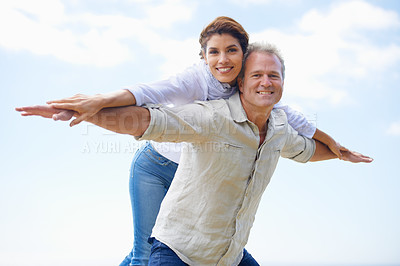 Buy stock photo Mature couple, portrait and piggy back on vacation, airplane hands and happiness in blue skies. Man, woman and bonding together with smile, marriage and commitment with affection, holiday and joyful
