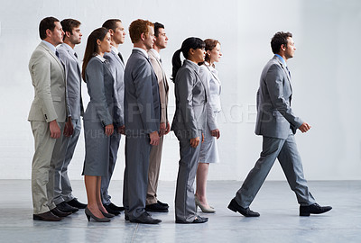 Buy stock photo A young business manager walking ahead of his colleagues - Leadership