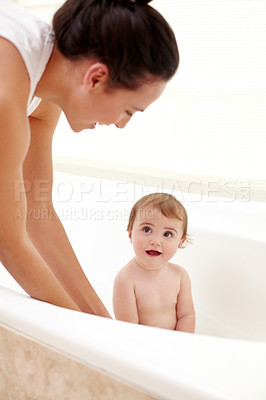 Buy stock photo Baby in bathtub with mom, water and clean fun in home for skincare, wellness and hygiene. Bubble bath, soap and happy child in bathroom with cute face, care and washing body of dirt, germs and mother