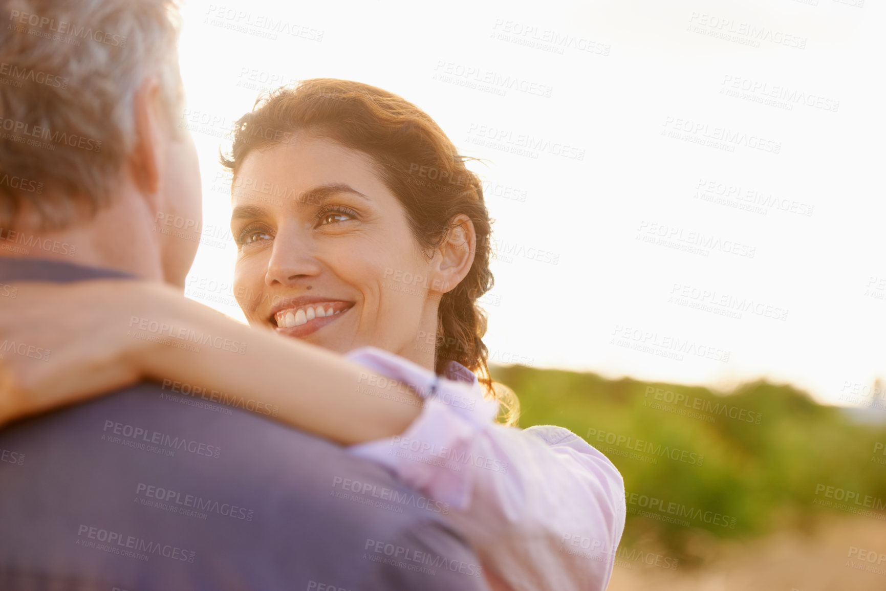 Buy stock photo Mature, couple and smile in embrace at sunset with love, trust and support in marriage or partnership. Happy, woman and care together with freedom, health or wellness at beach for vacation or holiday