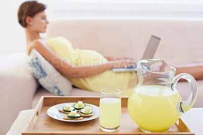 Buy stock photo Pregnant woman, food or laptop on sofa with healthy, nutrition or wellness for lunch or snack in living room. Person, lemonade or brunch or technology on couch for remote work, relax or home internet