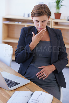 Buy stock photo A pregnant businesswoman battling with nausea at her desk