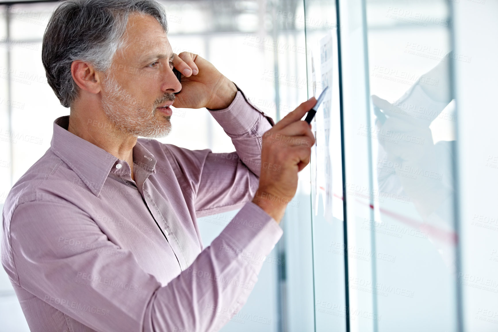 Buy stock photo Mature business man, thinking during phone call and ideas on glass board, agenda and brainstorming for ad campaign. Communication, problem solving and concentration, male worker and advertising plan