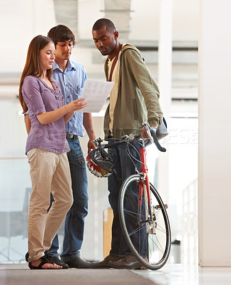 Buy stock photo People, talking and document in office with bicycle for travel or morning commute to workplace. Bike messenger, paper and discussion of business, logistics or checklist with employees or clients