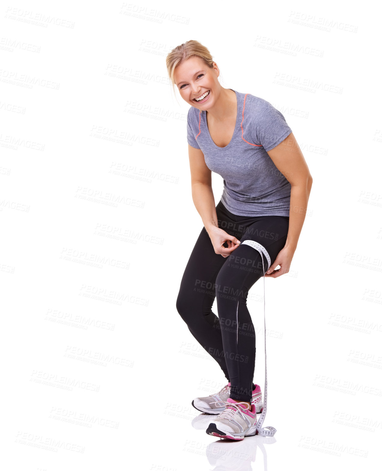 Buy stock photo Studio shot of an attractive young woman measuring her workout progress with a tape measure