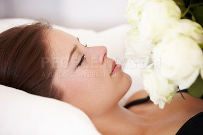 Buy stock photo Roses, flowers and woman sleeping on bed for resting, relax and peaceful with eyes closed. Flower bouquet, love and girl smell blossom of valentines day gift, present and romantic gesture in bedroom