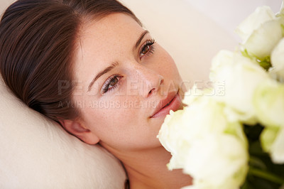 Buy stock photo Roses, woman and flowers with a young person on a pillow feeling rest, relax and calm. Bouquet, flower and beautiful female with plant in a bedroom at home looking at blossom present and gift 