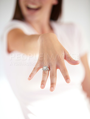 Buy stock photo Hand, engagement and woman with a diamond ring in a studio for valentines day, romance or anniversary. Love, happiness and closeup of a female model with fancy wedding jewelry by a white background.