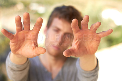 Buy stock photo A handsome young man holding up his calloused hands